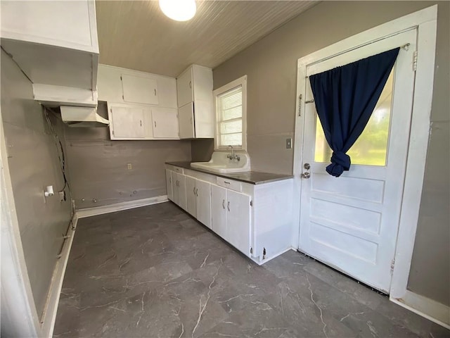 63070 Oak St, Roseland, LA 70456 - kitchen featuring a sink, white cabinets, wooden ceiling, and baseboards
