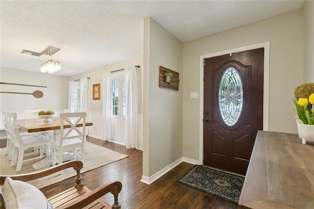 4212 Pommard Dr, Kenner, LA 70065 - foyer entrance featuring a chandelier, healthy amount of natural light, a textured ceiling, and dark wood finished floors