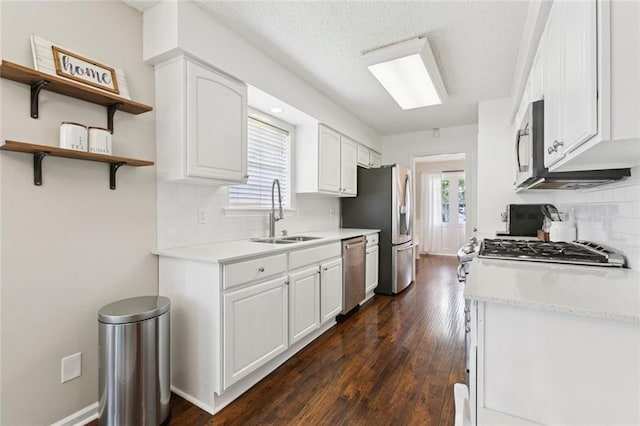 4212 Pommard Dr, Kenner, LA 70065 - kitchen featuring a sink, stainless steel appliances, backsplash, white cabinetry, and dark wood-style floors