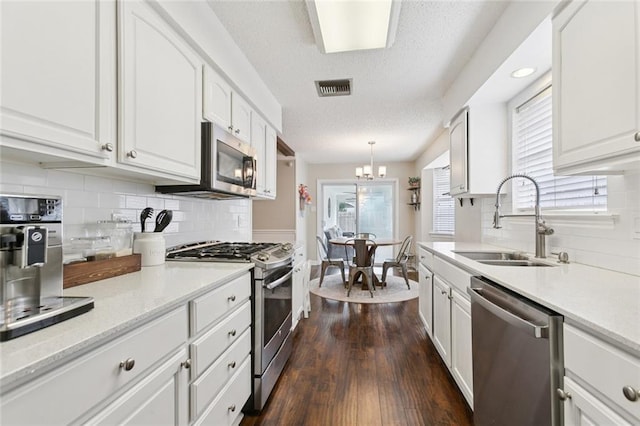 4212 Pommard Dr, Kenner, LA 70065 - kitchen with appliances with stainless steel finishes, a sink, white cabinetry, a textured ceiling, and backsplash