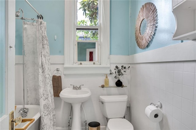 8301 Belfast St Unit 8303, New Orleans, LA 70118 - full bath featuring tile walls, toilet, shower / tub combo with curtain, wainscoting, and a sink