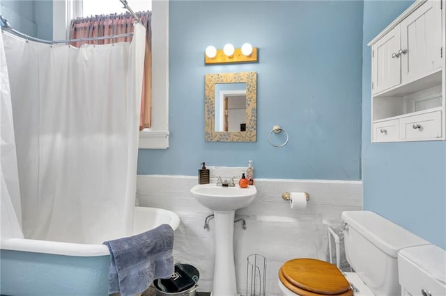 8301 Belfast St Unit 8303, New Orleans, LA 70118 - full bathroom featuring toilet, a wainscoted wall, and tile walls