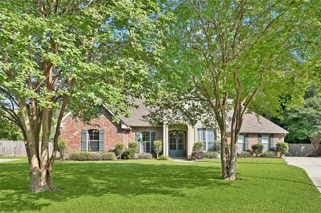 1061 Tallow Tree Dr, Mandeville, LA 70448 - obstructed view of property featuring brick siding, roof with shingles, and concrete driveway