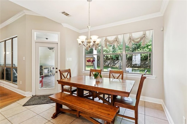 1061 Tallow Tree Dr, Mandeville, LA 70448 - dining space featuring light tile patterned floors, crown molding, a chandelier, and baseboards