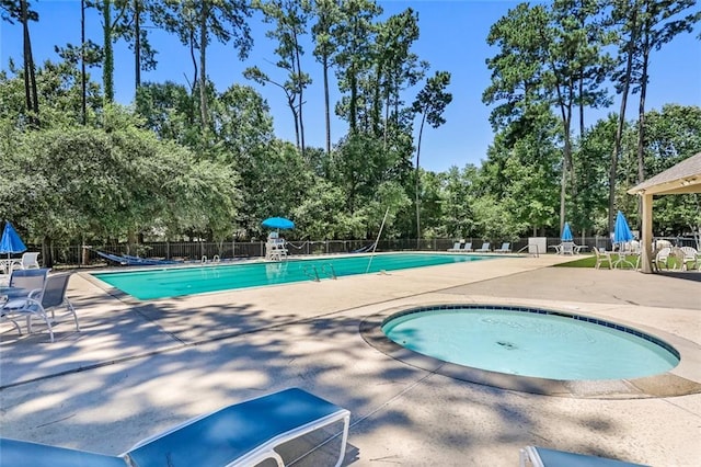 1061 Tallow Tree Dr, Mandeville, LA 70448 - community pool with a patio area, view of scattered trees, and a hot tub