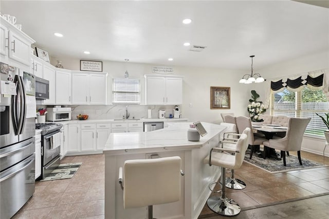 728 Fairfield Loop, Slidell, LA 70458 - kitchen with stainless steel appliances, a sink, a kitchen bar, white cabinets, and recessed lighting