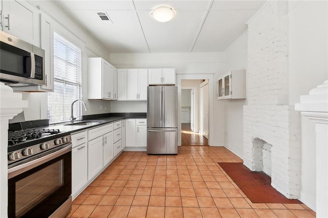 3019 Burdette St, New Orleans, LA 70125 - kitchen with appliances with stainless steel finishes, a sink, light tile patterned floors, and white cabinetry