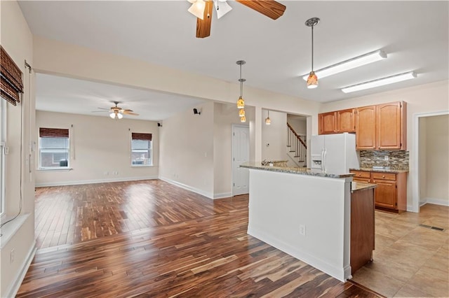 816 Celeste Ave, River Ridge, LA 70123 - kitchen featuring white fridge with ice dispenser, a ceiling fan, light stone countertops, hanging light fixtures, and backsplash
