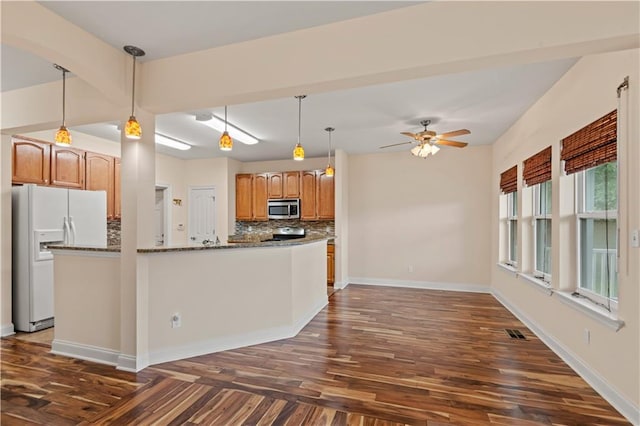 816 Celeste Ave, River Ridge, LA 70123 - kitchen with white refrigerator with ice dispenser, stainless steel microwave, tasteful backsplash, dark wood-style floors, and a ceiling fan