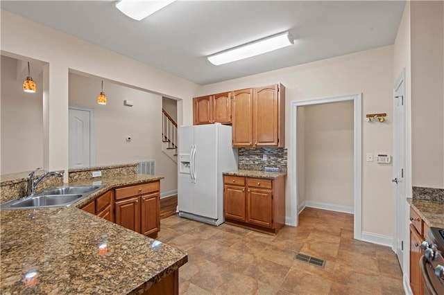 816 Celeste Ave, River Ridge, LA 70123 - kitchen featuring white fridge with ice dispenser, a sink, stainless steel range, decorative backsplash, and baseboards