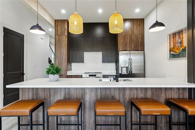 2404 Danneel St, New Orleans, LA 70113 - kitchen featuring appliances with stainless steel finishes, a sink, light countertops, modern cabinets, and recessed lighting