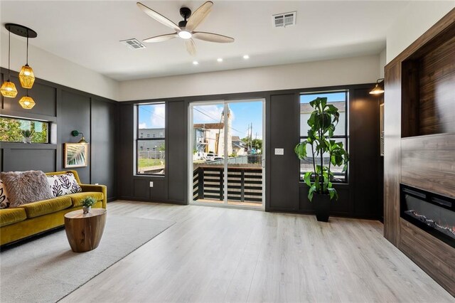 2404 Danneel St, New Orleans, LA 70113 - living area with a ceiling fan, light wood-style flooring, a glass covered fireplace, and recessed lighting