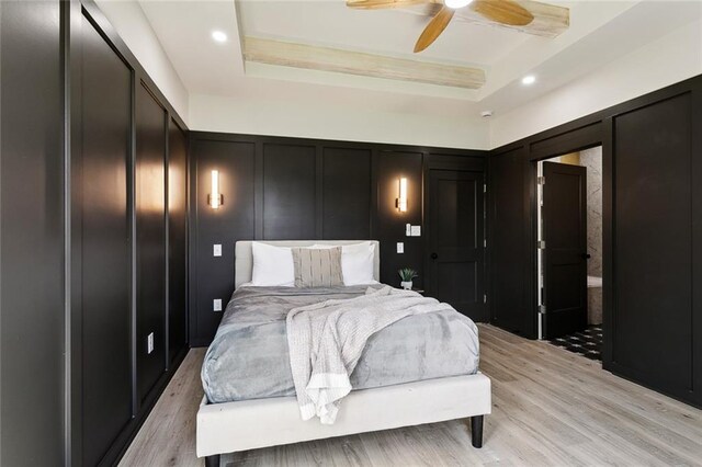 2404 Danneel St, New Orleans, LA 70113 - bedroom with a decorative wall, light wood-type flooring, a tray ceiling, a ceiling fan, and recessed lighting