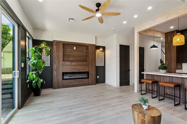 2404 Danneel St, New Orleans, LA 70113 - living room featuring light wood-type flooring, ceiling fan, a glass covered fireplace, recessed lighting, and baseboards
