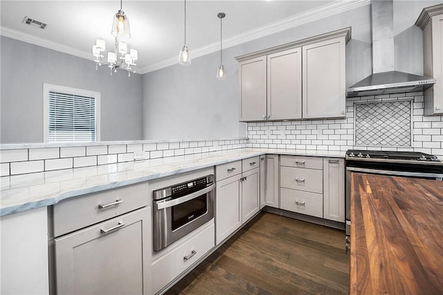 615 Newman Ave, Jefferson, LA 70121 - kitchen featuring wall chimney range hood, gray cabinetry, ornamental molding, and light stone counters