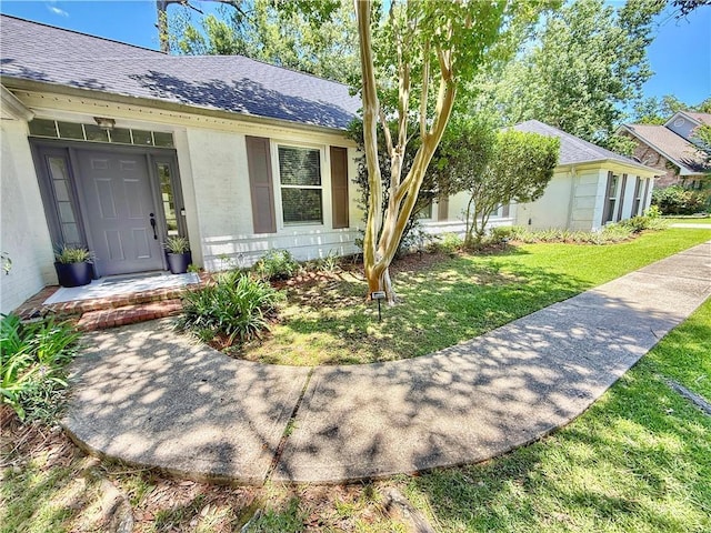 44 Stonebridge Ct, Mandeville, LA 70448 - doorway to property featuring roof with shingles and a yard