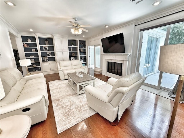44 Stonebridge Ct, Mandeville, LA 70448 - living area with ornamental molding, a ceiling fan, wood finished floors, a tiled fireplace, and recessed lighting