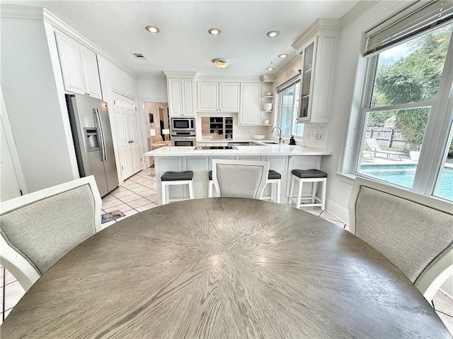 44 Stonebridge Ct, Mandeville, LA 70448 - kitchen featuring stainless steel appliances, a peninsula, open shelves, glass insert cabinets, and white cabinets