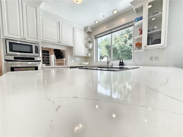 44 Stonebridge Ct, Mandeville, LA 70448 - kitchen with open shelves, stainless steel appliances, white cabinetry, and backsplash