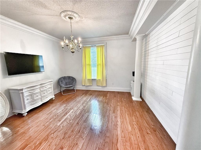 44 Stonebridge Ct, Mandeville, LA 70448 - living room featuring a chandelier, a textured ceiling, wood finished floors, ornamental molding, and baseboards