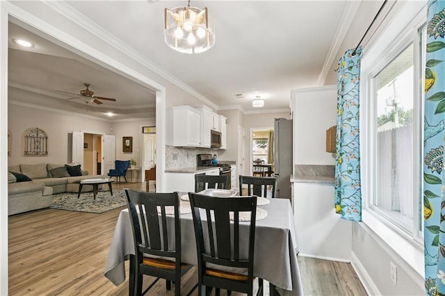 5714 Vicksburg St, New Orleans, LA 70124 - dining space featuring wood finished floors, a chandelier, ceiling fan, crown molding, and baseboards
