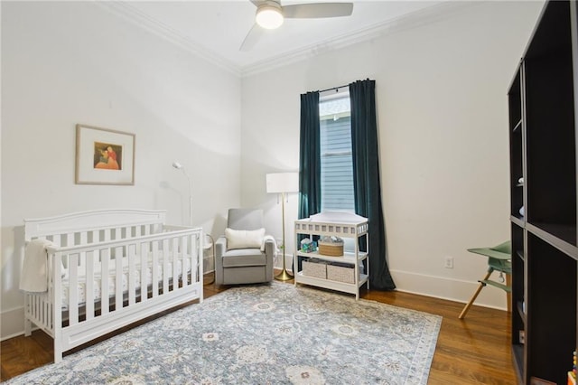 718 Monroe St, Gretna, LA 70053 - bedroom featuring crown molding, wood finished floors, baseboards, a crib, and a ceiling fan