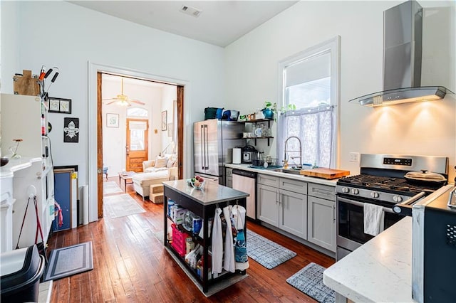 352123 Cleveland Ave, New Orleans, LA 70119 - kitchen featuring wall chimney range hood, stainless steel appliances, dark wood-type flooring, a sink, and open shelves