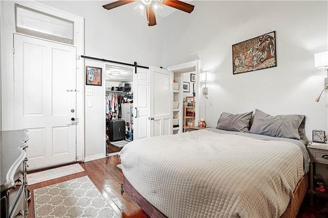 352123 Cleveland Ave, New Orleans, LA 70119 - bedroom with a barn door, hardwood / wood-style floors, a high ceiling, a closet, and a ceiling fan