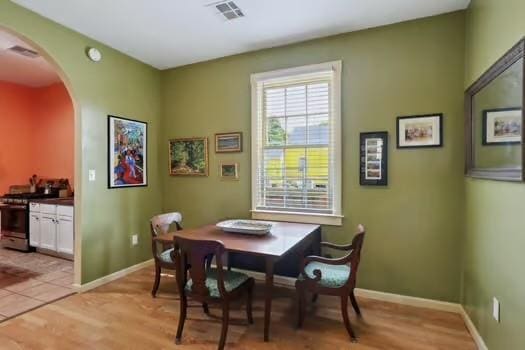 640 Lizardi St, New Orleans, LA 70117 - dining room featuring arched walkways, light wood finished floors, and baseboards