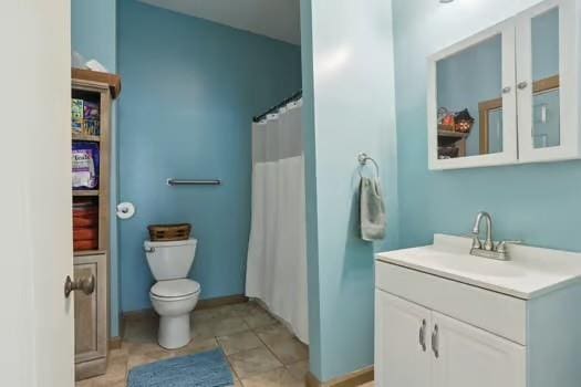 640 Lizardi St, New Orleans, LA 70117 - full bath with vanity, toilet, a shower with shower curtain, and tile patterned flooring