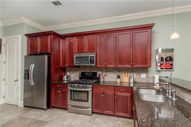 23783 Monarch Pt, Springfield, LA 70462 - kitchen with stainless steel appliances, reddish brown cabinets, a sink, crown molding, and backsplash