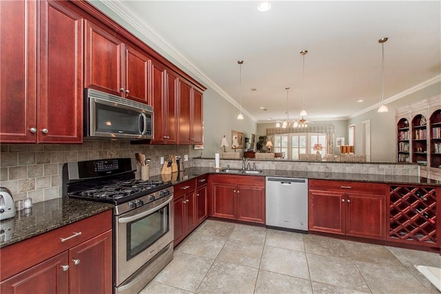 23783 Monarch Pt, Springfield, LA 70462 - kitchen with stainless steel appliances, dark brown cabinets, a sink, ornamental molding, and tasteful backsplash