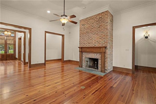 580 Northwoods Dr, Abita Springs, LA 70420 - unfurnished living room featuring hardwood / wood-style floors, ceiling fan, crown molding, a fireplace, and baseboards