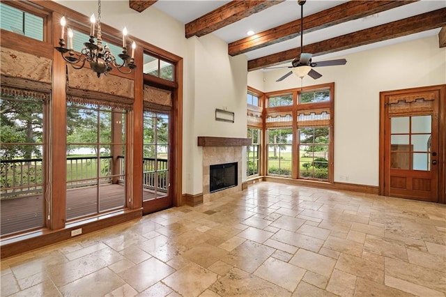 580 Northwoods Dr, Abita Springs, LA 70420 - unfurnished living room with baseboards, stone tile floors, a ceiling fan, healthy amount of natural light, and a high ceiling