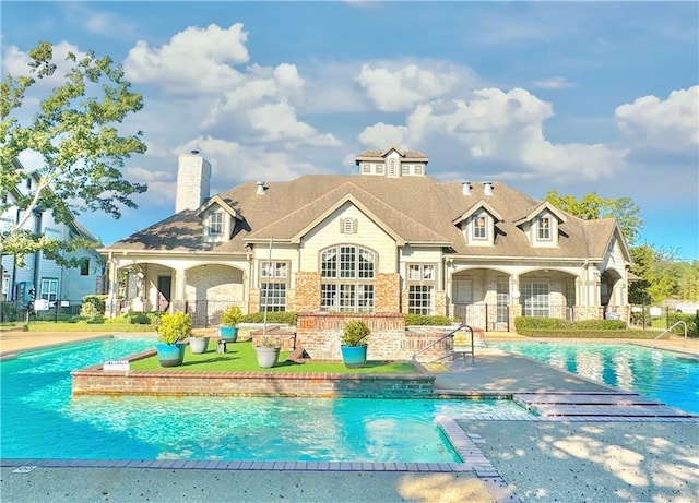 350 Emerald Forest Blvd Unit 11202, Covington, LA 70433 - back of property with an outdoor pool, a chimney, stone siding, and a patio