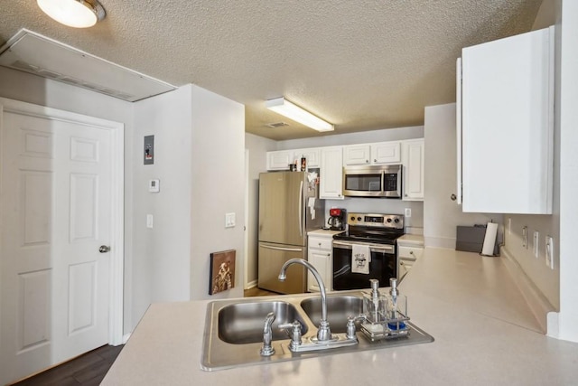 350 Emerald Forest Blvd Unit 11202, Covington, LA 70433 - kitchen with stainless steel appliances, light countertops, a sink, white cabinets, and a textured ceiling