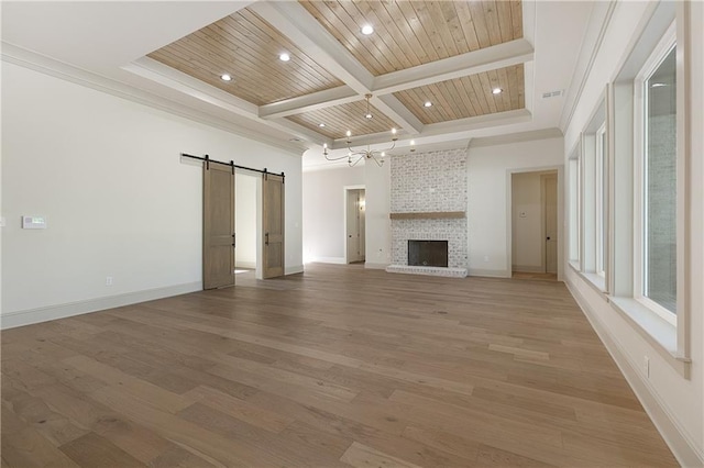 391 Rue Charlotte St, Madisonville, LA 70447 - unfurnished living room with a barn door, beam ceiling, light wood finished floors, coffered ceiling, and a fireplace
