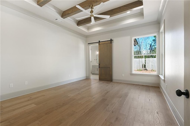 391 Rue Charlotte St, Madisonville, LA 70447 - unfurnished room featuring a barn door, light wood-style floors, beam ceiling, a ceiling fan, and a raised ceiling