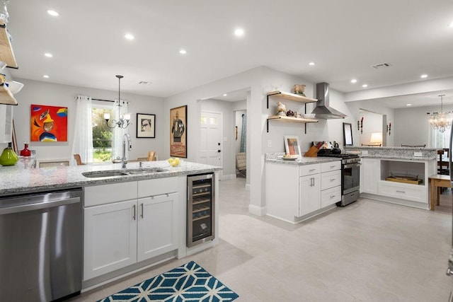 1012 W 11th Ave, Covington, LA 70433 - kitchen with appliances with stainless steel finishes, wall chimney range hood, a sink, a chandelier, and wine cooler