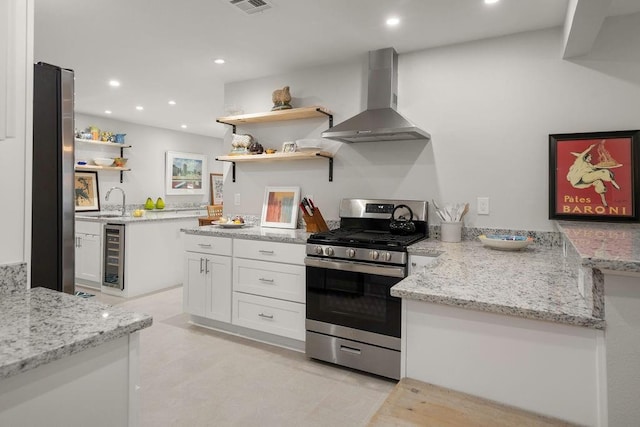 1012 W 11th Ave, Covington, LA 70433 - kitchen featuring wall chimney range hood, open shelves, appliances with stainless steel finishes, wine cooler, and white cabinets
