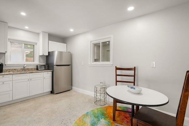 1012 W 11th Ave, Covington, LA 70433 - kitchen featuring freestanding refrigerator, a sink, baseboards, white cabinetry, and recessed lighting