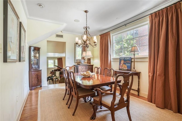 43 Farnham Pl, Metairie, LA 70005 - dining room with ornamental molding, plenty of natural light, a chandelier, baseboards, and light wood-style floors