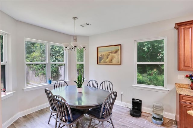 28628 Violet St, Lacombe, LA 70445 - dining area featuring a chandelier, light wood-style floors, and baseboards