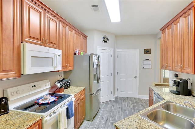 28628 Violet St, Lacombe, LA 70445 - kitchen featuring stainless steel appliances, a sink, light wood-style floors, baseboards, and light stone countertops