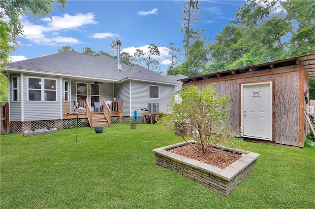28628 Violet St, Lacombe, LA 70445 - rear view of property featuring a wooden deck, ceiling fan, an outbuilding, and a lawn