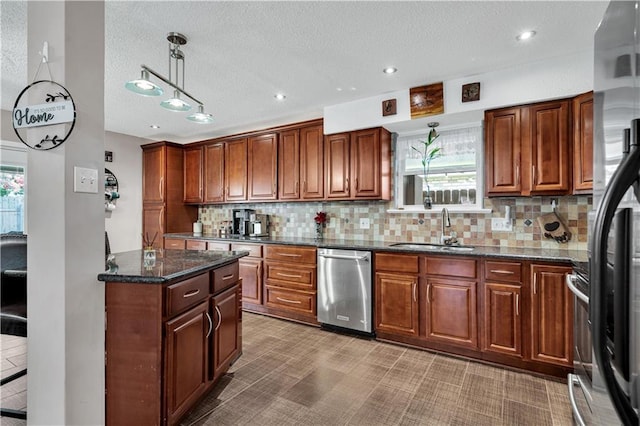 3140 Arbutus Ln, Marrero, LA 70072 - kitchen with stainless steel appliances, a sink, a textured ceiling, decorative backsplash, and dark stone counters