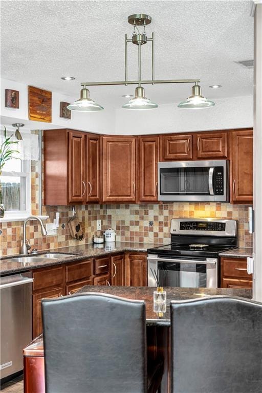 3140 Arbutus Ln, Marrero, LA 70072 - kitchen with appliances with stainless steel finishes, a sink, tasteful backsplash, a textured ceiling, and brown cabinets