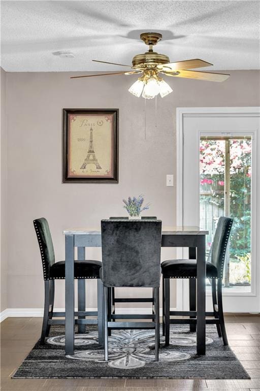 3140 Arbutus Ln, Marrero, LA 70072 - dining room featuring a textured ceiling, ceiling fan, wood finished floors, and baseboards