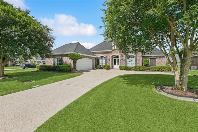 108 Parkview Dr, La Place, LA 70068 - french country home with a garage, brick siding, a front lawn, and driveway