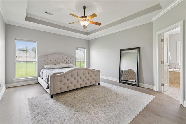 108 Parkview Dr, La Place, LA 70068 - bedroom featuring wood finished floors, ornamental molding, a tray ceiling, and baseboards
